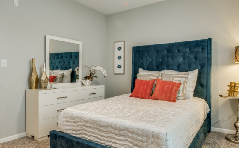 a bedroom with a blue headboard and a nightstand at The  Sophia